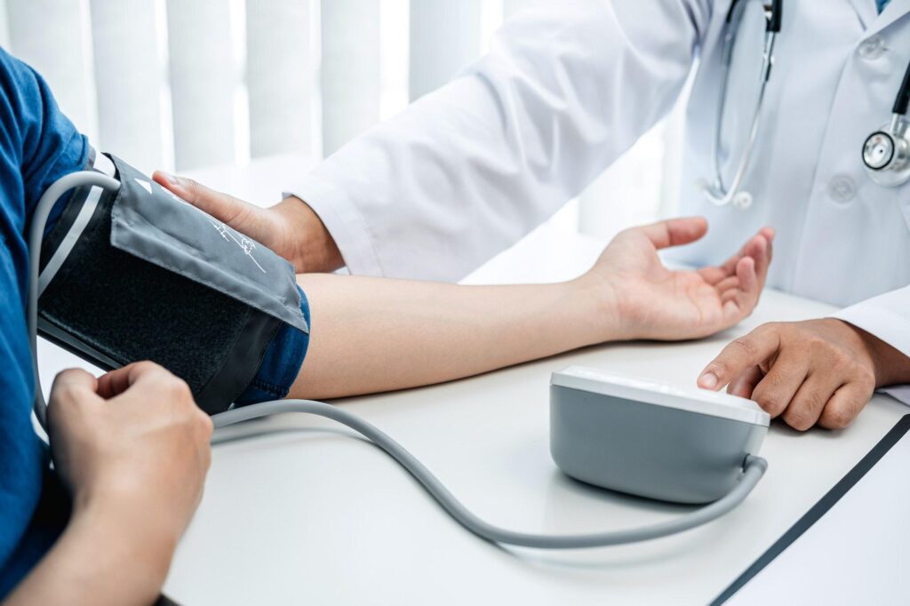 doctor is checking blood pressure using a stethoscope check for the cause of the patient's illness